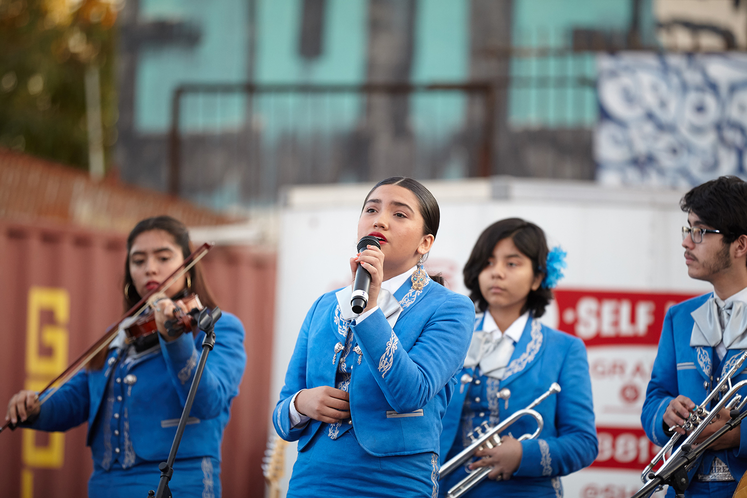 High school students wearing mariachi clothing doing a musical performance.